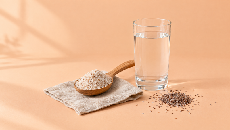 Wooden spoon of psyllium husk beside a glass of water