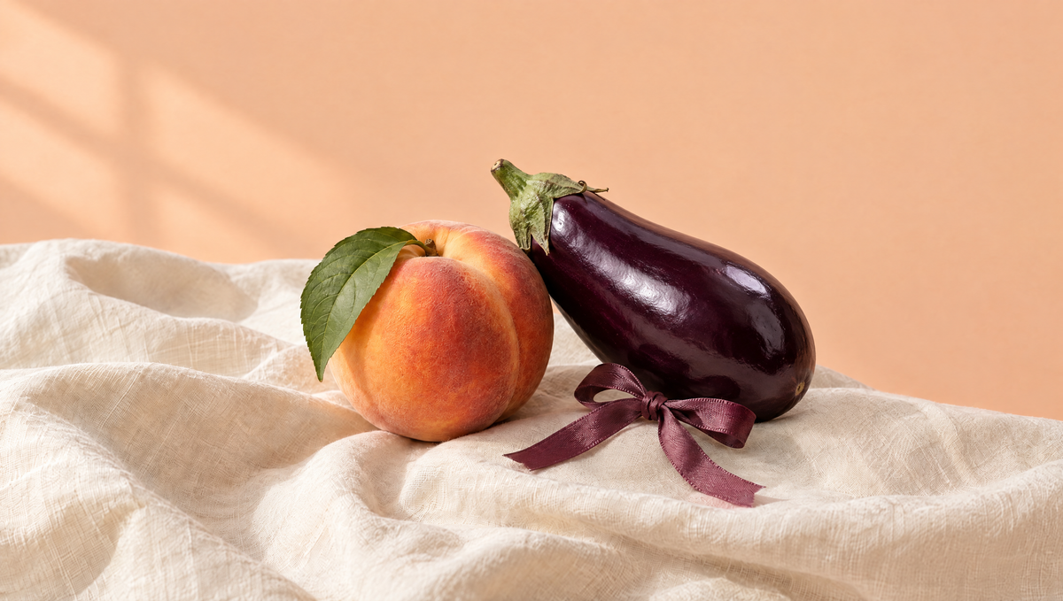 A peach and an eggplant on soft linen with a plum ribbon