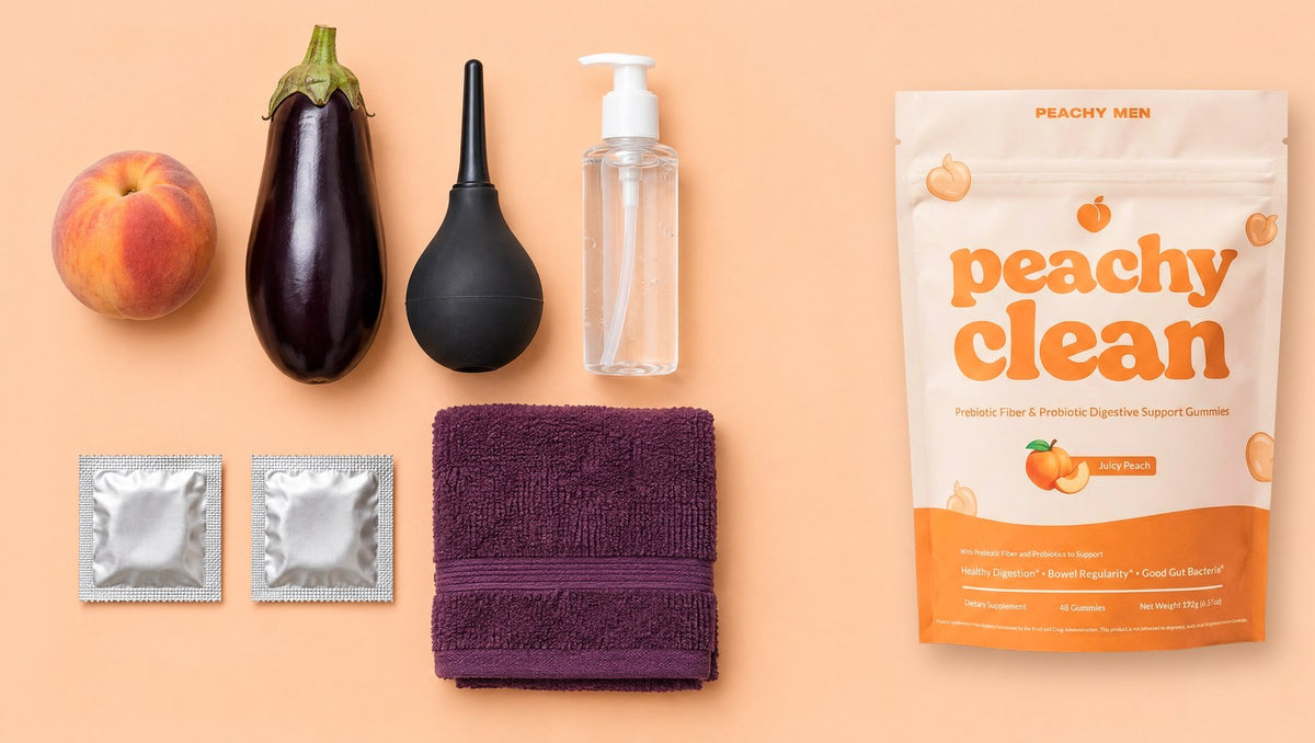 Bottoming prep kit with a peach, eggplant, douche bulb, lube, condoms, towel and the Peachy Clean bag