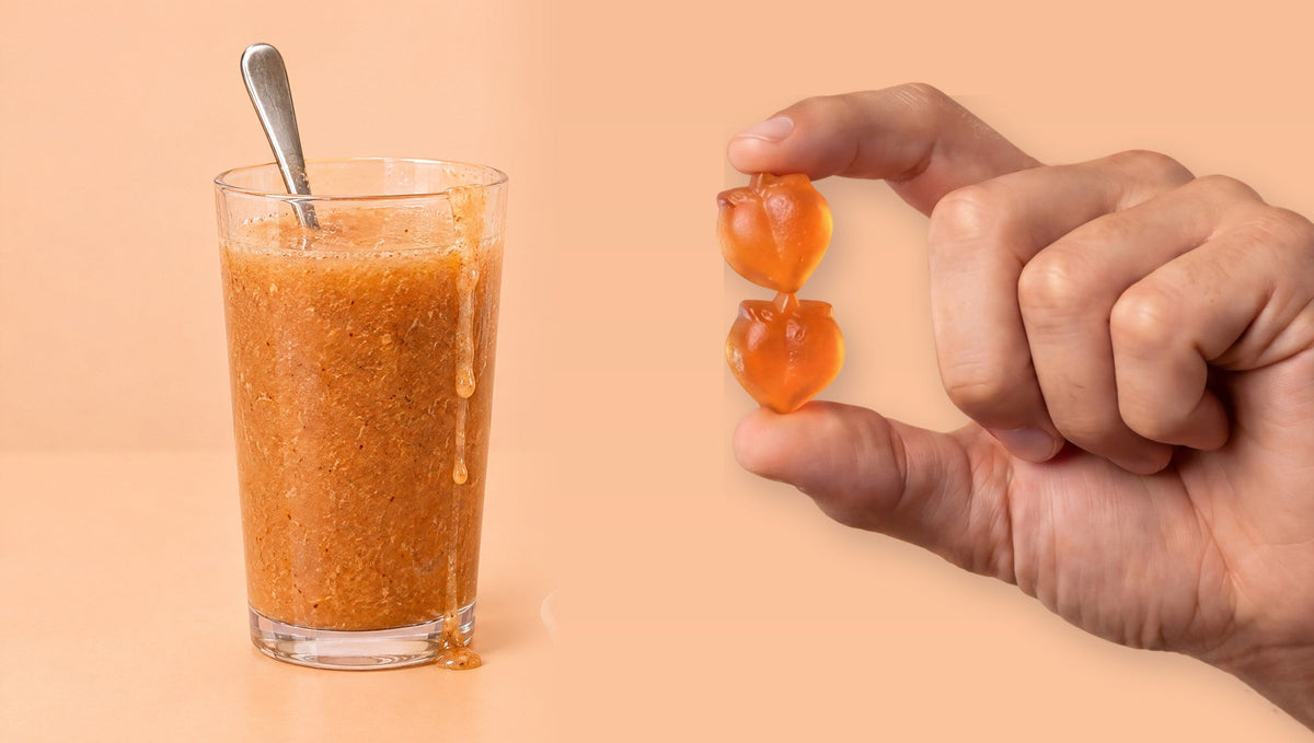 Glass of thick orange psyllium drink next to a hand holding two Peachy Clean gummies